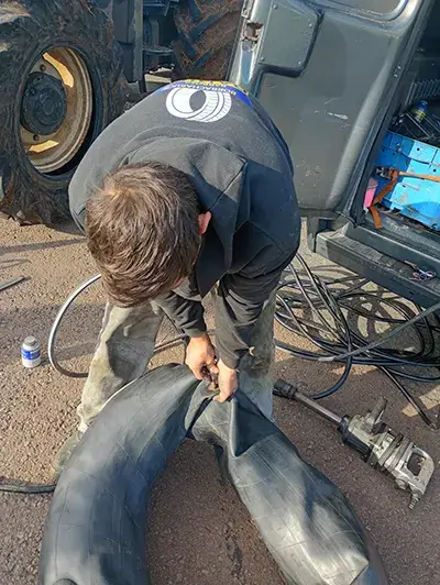 Profissional realizando atendimento de borracharia em um caminhão